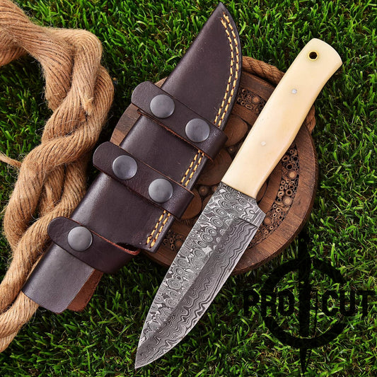 Knife with leather sheath and wooden handle on grass, featuring a brand logo.