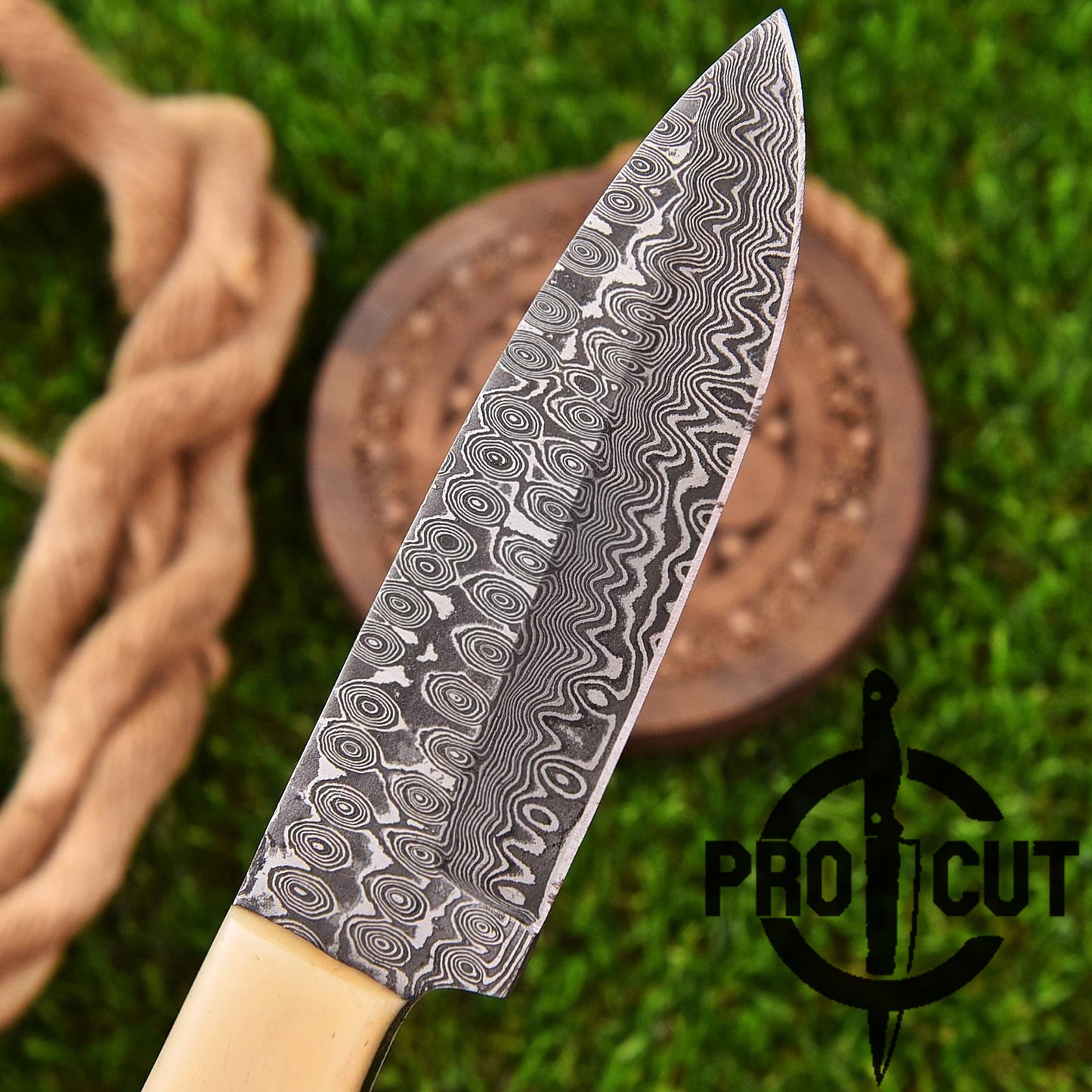 Decorative knife with wavy pattern on a wooden block against a green grass background, featuring the Pro Cut logo.
